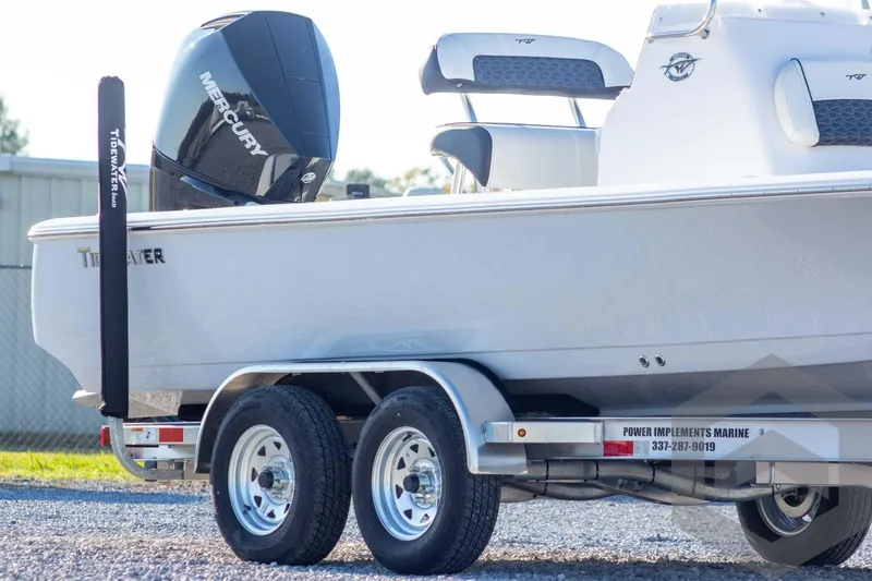 Slide: The Image of 2026 Tidewater 2110 Bay Max boat on trailer with Mercury engine, parked outdoors. - 6