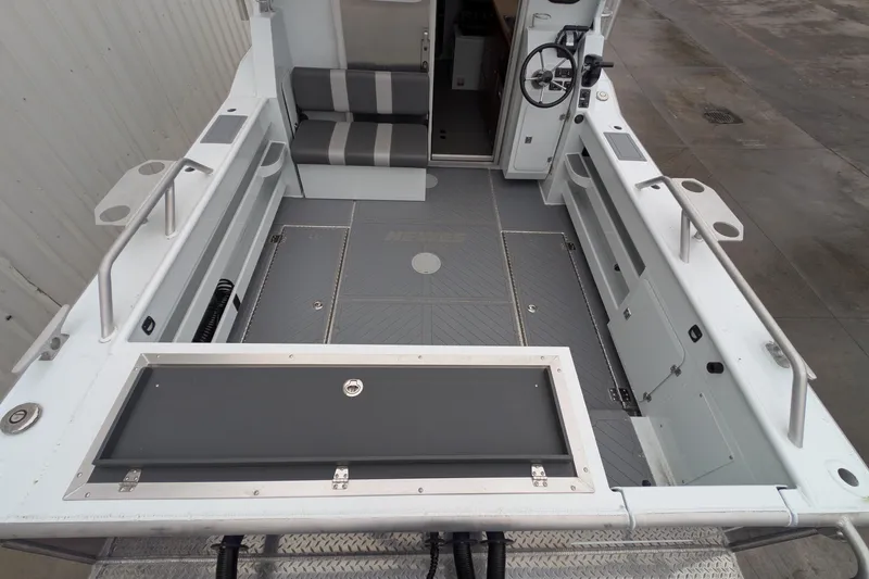 Slide: The Image of 2022 Hewscraft Pacific Explorer boat interior with seating, steering wheel, and storage compartments. - 15