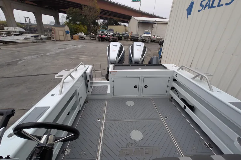 Slide: The Image of 2022 Hewscraft Pacific Explorer boat interior with dual engines, docked near sales building. - 16