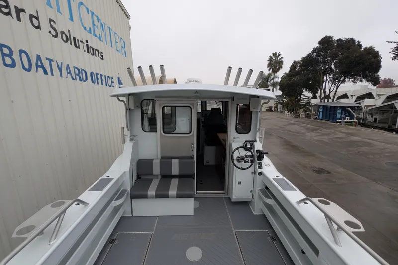 Slide: The Image of 2022 Hewscraft Pacific Explorer boat interior at a boatyard, featuring seating and steering wheel. - 17