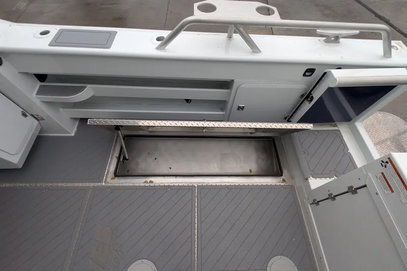 Slide: The Image of 2022 Hewscraft Pacific Explorer boat interior with open storage compartment and sleek design. - 21