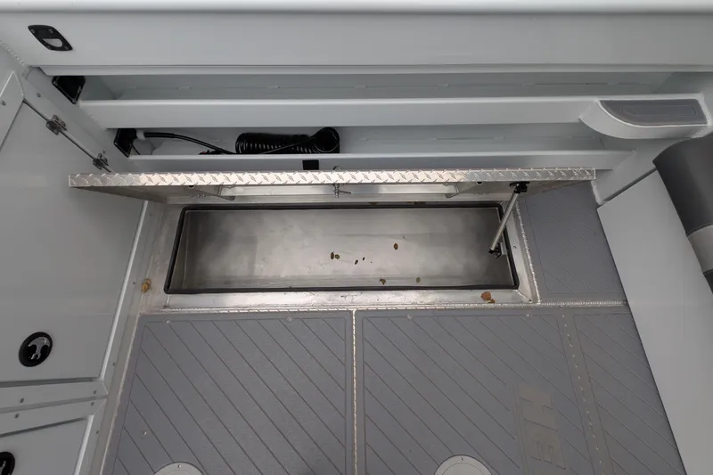Slide: The Image of 2022 Hewscraft Pacific Explorer boat storage compartment with open hatch and clean interior. - 22