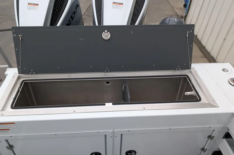 Slide: The Image of 2022 Hewscraft Pacific Explorer boat storage compartment with open lid, showcasing interior space. - 24