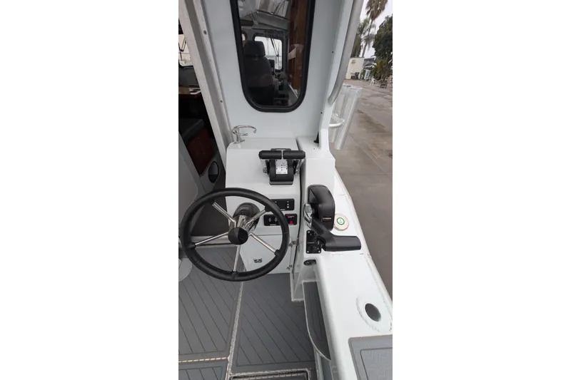 Slide: The Image of 2022 Hewscraft Pacific Explorer boat helm with steering wheel and controls. - 25