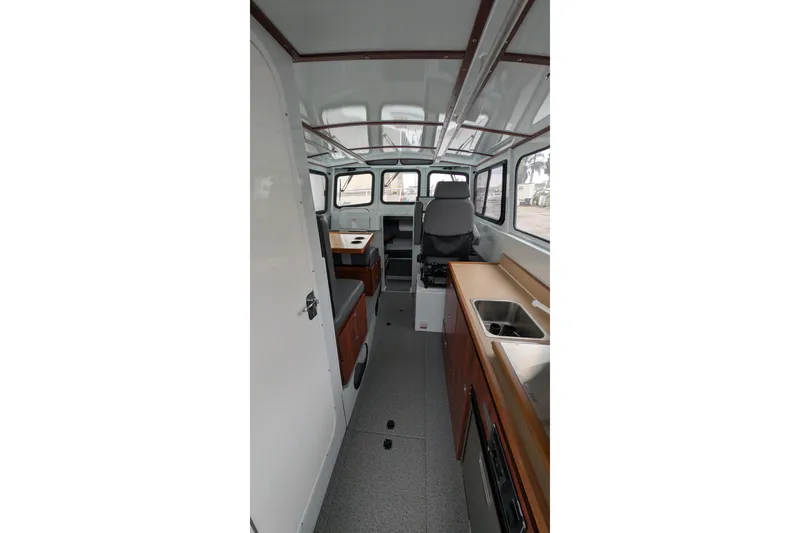 Slide: The Image of Interior of 2022 Hewscraft Pacific Explorer boat, featuring seating and kitchenette. - 27