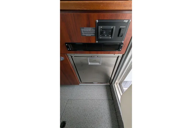 Slide: The Image of 2022 Hewscraft Pacific Explorer interior with wood paneling and built-in refrigerator. - 31