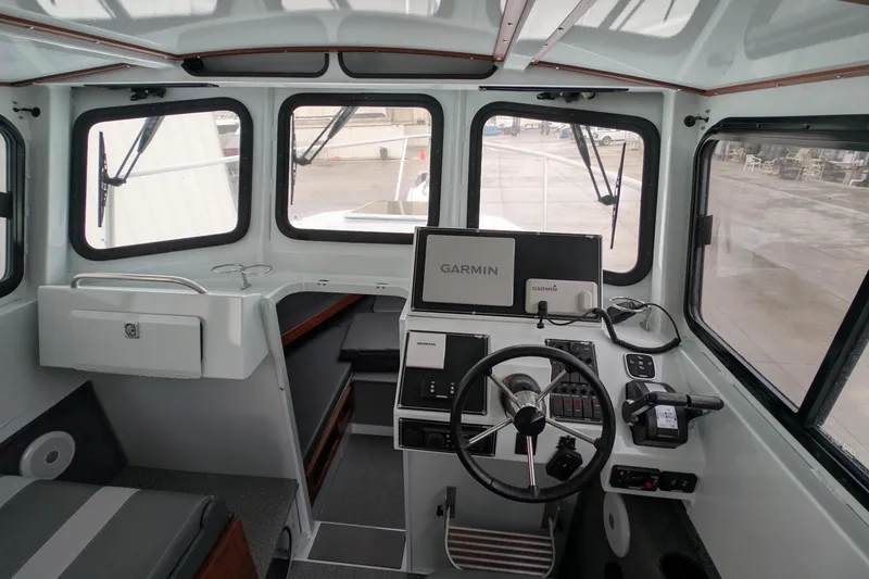 Slide: The Image of 2022 Hewscraft Pacific Explorer boat interior with Garmin navigation system and steering wheel. - 35