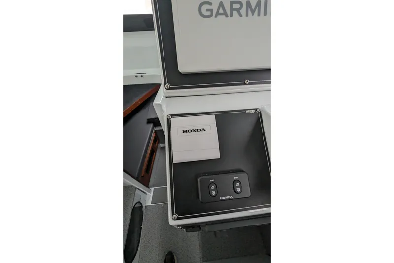 Slide: The Image of 2022 Hewscraft Pacific Explorer boat dashboard with Honda controls and Garmin equipment. - 42