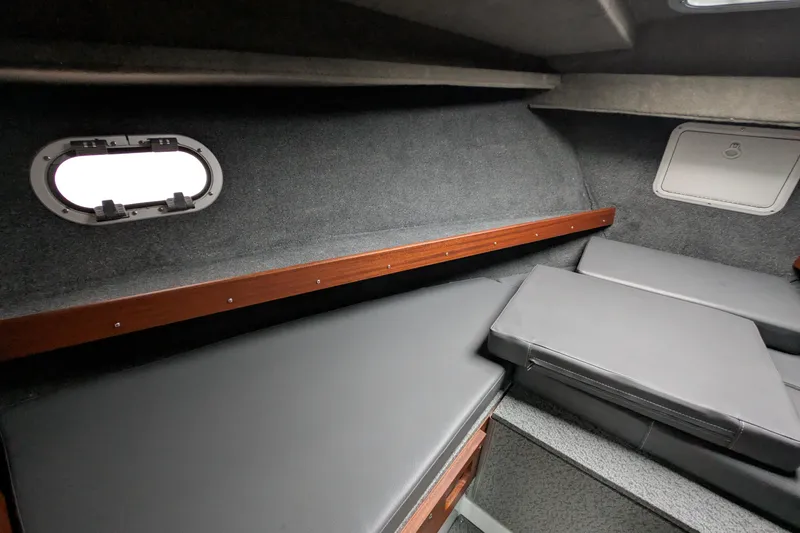 Slide: The Image of 2022 Hewscraft Pacific Explorer cabin interior with cushioned seating and porthole window. - 44