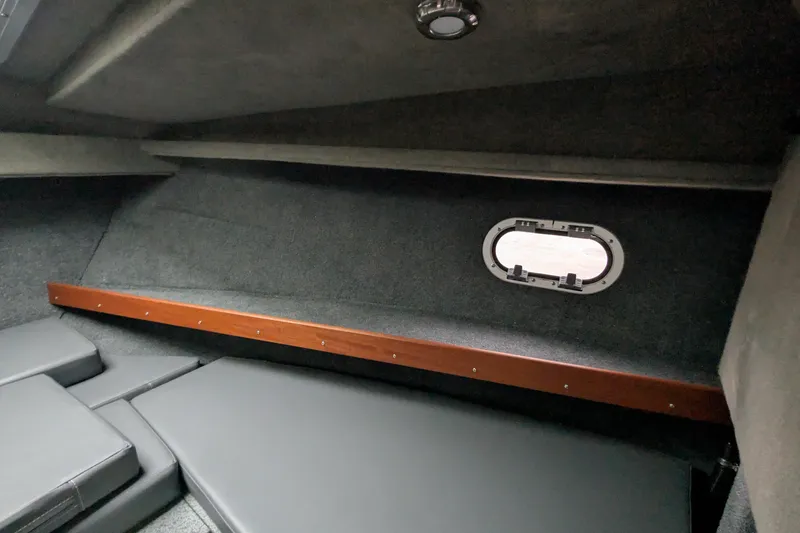 Slide: The Image of 2022 Hewscraft Pacific Explorer cabin interior with cushioned seating and porthole window. - 45