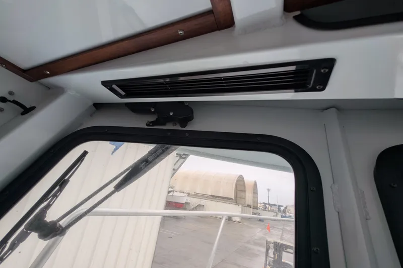 Slide: The Image of Interior view of 2022 Hewscraft Pacific Explorer boat cabin with window and vent. - 47