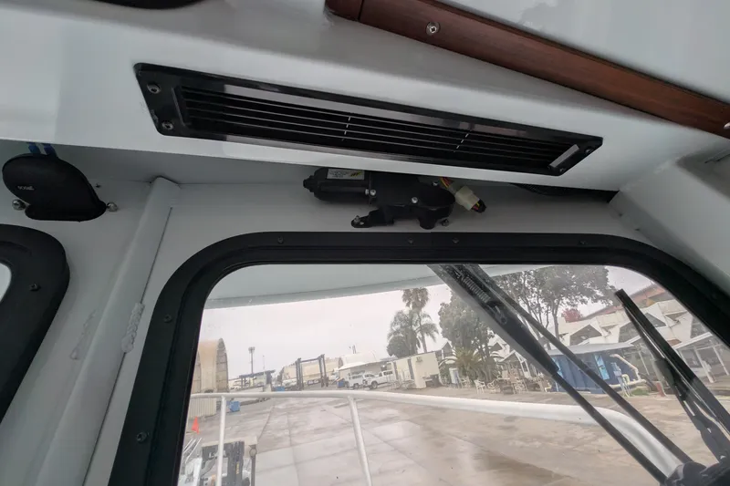 Slide: The Image of Interior view of a 2022 Hewscraft Pacific Explorer boat, showing window and dashboard details. - 48