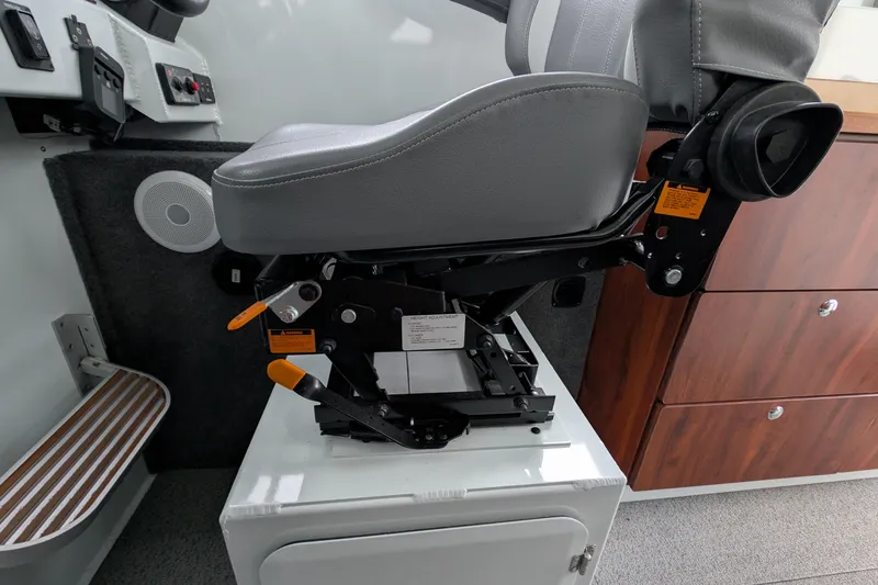 Slide: The Image of 2022 Hewscraft Pacific Explorer interior with adjustable captain's chair and control panel. - 49