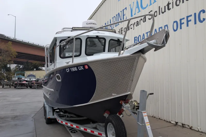 Slide: The Image of 2022 Hewscraft Pacific Explorer boat on trailer near a marine yard. - 6