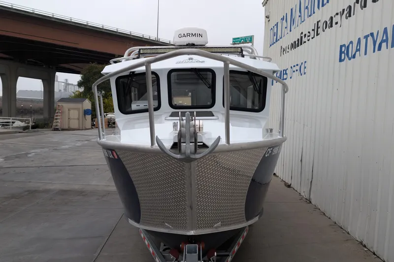 Slide: The Image of 2022 Hewscraft Pacific Explorer boat docked near a marina under a bridge. - 9
