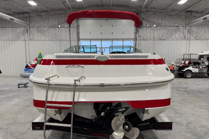 Slide: The Image of 1995 Cobalt 252 boat with red accents in a spacious indoor storage facility. - 11