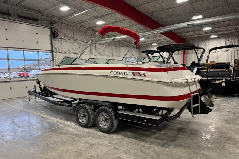 Slide: The Image of 1995 Cobalt 252 boat with red accents on a trailer in a spacious garage. - 7