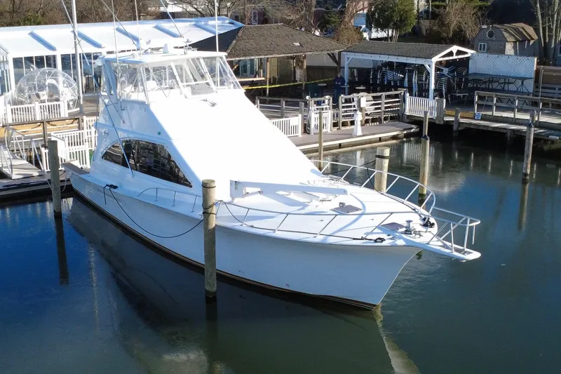 Slide: The Image of 1999 Ocean Yachts 56 Super Sport docked at a marina, showcasing sleek design and luxury. - 10