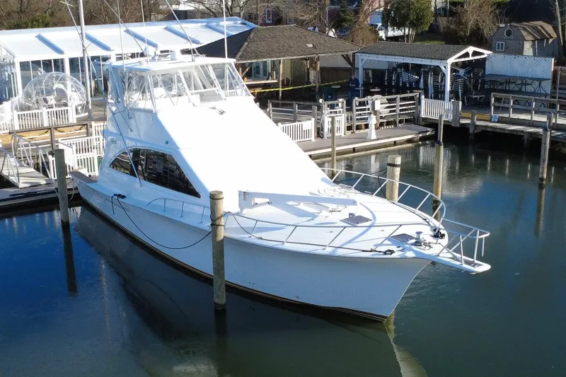Slide: The Image of 1999 Ocean Yachts 56 Super Sport docked at a marina, showcasing sleek design. - 11