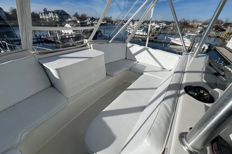 Slide: The Image of 1999 Ocean Yachts 56 Super Sport yacht interior with white seating and marina view. - 15