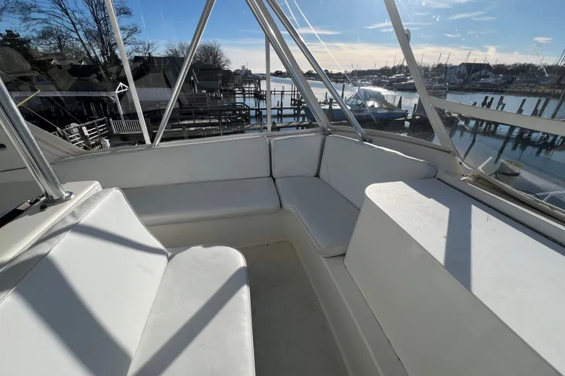 Slide: The Image of 1999 Ocean Yachts 56 Super Sport interior with white seating, overlooking marina. - 16
