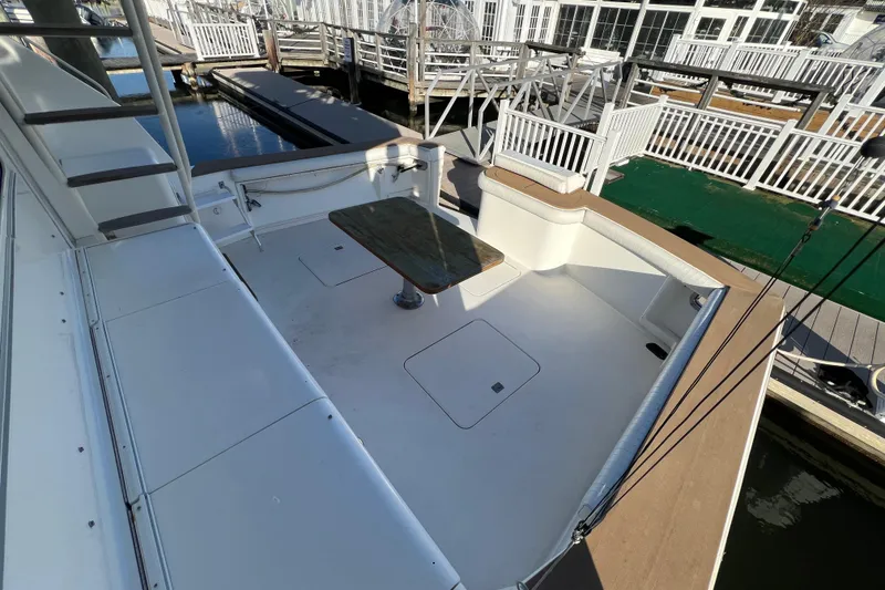 Slide: The Image of 1999 Ocean Yachts 56 Super Sport deck with table, docked at marina. - 21