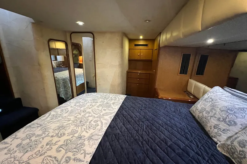 Slide: The Image of Luxurious bedroom interior of 1999 Ocean Yachts 56 Super Sport with elegant bedding and wood cabinetry. - 26
