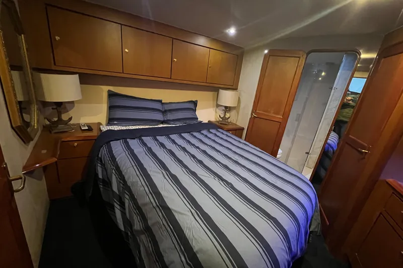 Slide: The Image of Cozy bedroom in 1999 Ocean Yachts 56 Super Sport with striped bedding and wooden cabinetry. - 40
