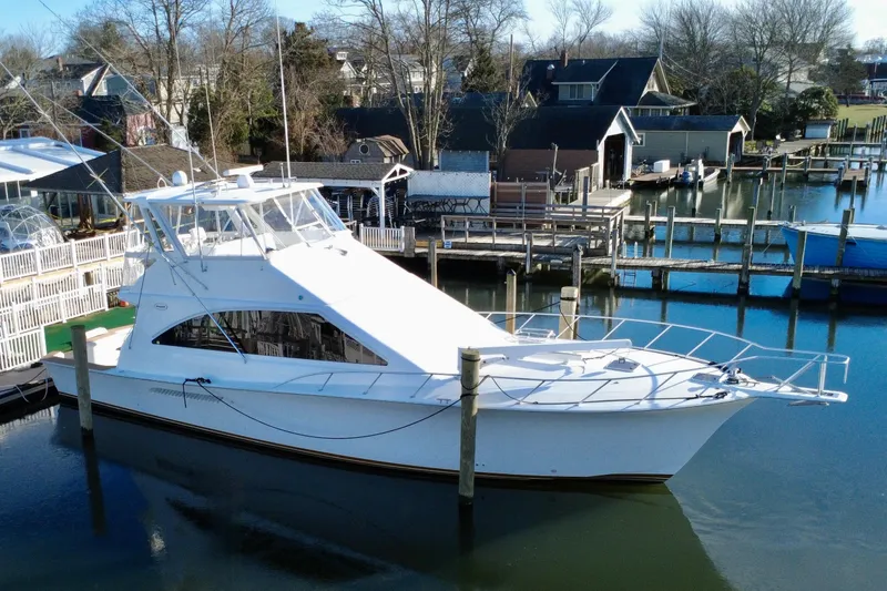 The Image of 1999 Ocean Yachts 56 Super Sport docked in a serene marina setting. - 0