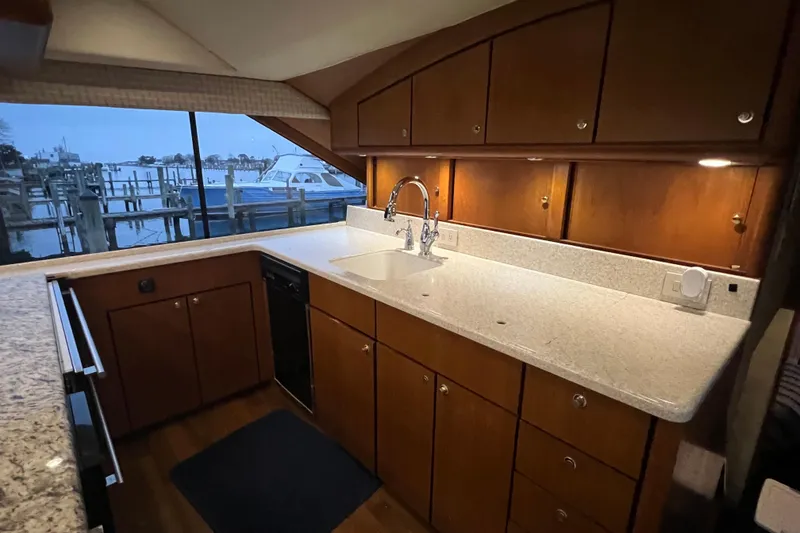 Slide: The Image of Luxurious kitchen interior of 1999 Ocean Yachts 56 Super Sport with wooden cabinets and marina view. - 52