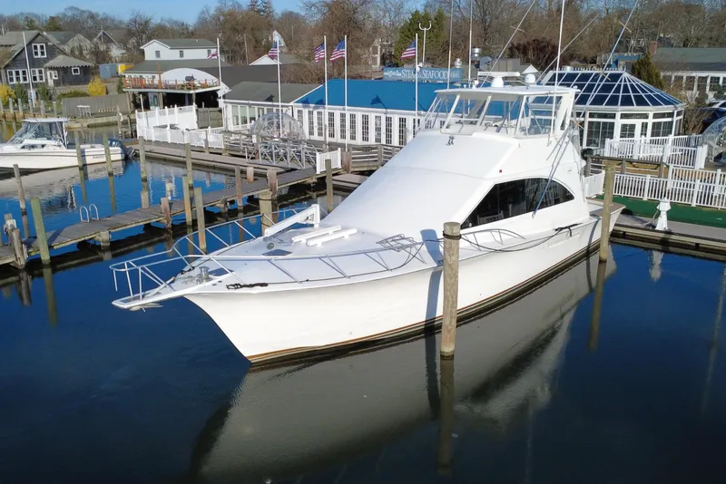 Slide: The Image of 1999 Ocean Yachts 56 Super Sport docked at a marina with waterfront buildings. - 6