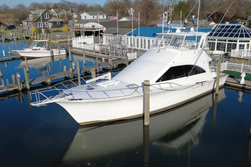 Slide: The Image of 1999 Ocean Yachts 56 Super Sport docked at a marina, surrounded by calm waters. - 8