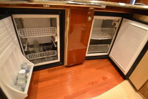 Slide: The Image of 2007 Sea Ray Sundancer 520 yacht kitchen with open refrigerators and wooden flooring. - 19