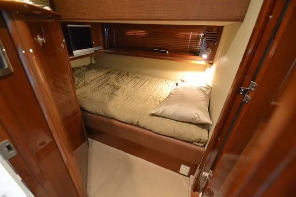 Slide: The Image of Cozy cabin interior of 2007 Sea Ray Sundancer 520 yacht with bed and wooden accents. - 23
