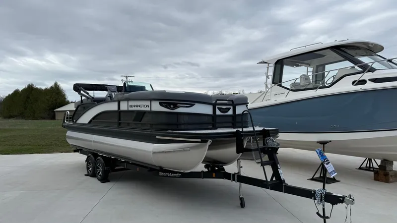 Slide: The Image of Bennington 22MOFB-SPS (TC) 2026 on trailer, next to blue boat. - 21