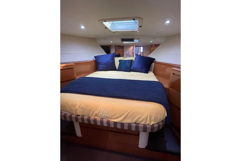 Slide: The Image of Cozy bedroom in 1999 Hatteras 52 Sport Deck Motor Yacht with skylight and blue accents. - 12