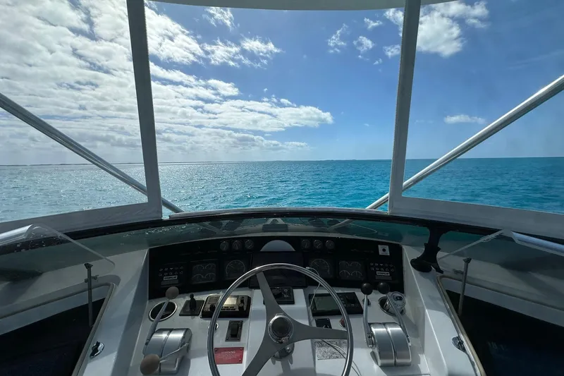 Slide: The Image of 1999 Hatteras 52 Sport Deck Motor Yacht helm with ocean view under blue sky. - 5