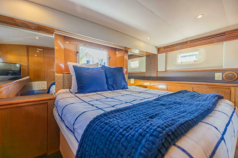 Slide: The Image of Luxurious bedroom interior of 1999 Hatteras 52 Sport Deck Motor Yacht with blue bedding. - 9