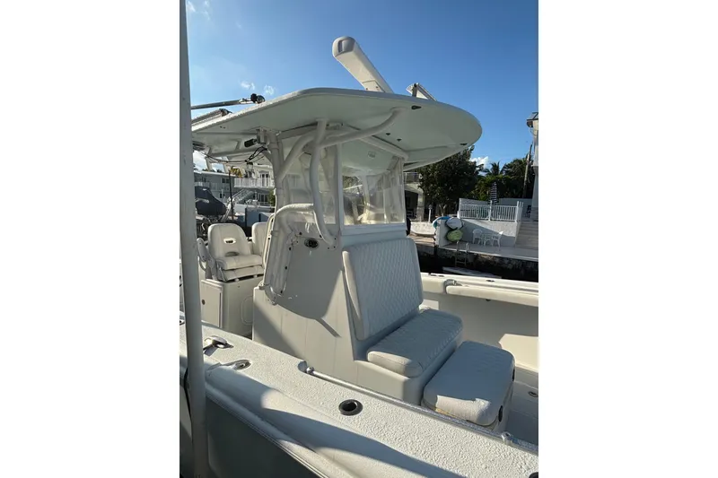 Slide: The Image of 2012 Yellowfin 32 Offshore boat with seating and canopy, docked under clear blue sky. - 10