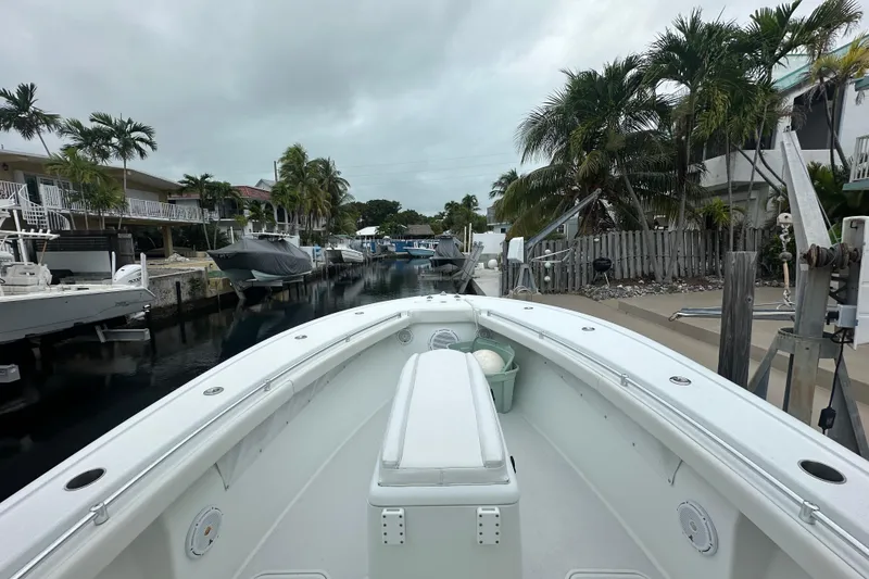 Slide: The Image of 2012 Yellowfin 32 Offshore boat docked in a tropical canal setting. - 11