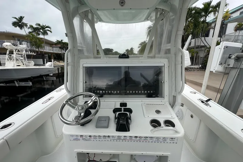 Slide: The Image of 2012 Yellowfin 32 Offshore boat cockpit with steering wheel and control panel. - 2
