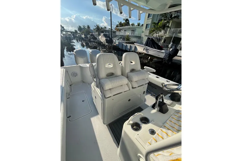 Slide: The Image of 2012 Yellowfin 32 Offshore boat interior with dual seats and canal view. - 4