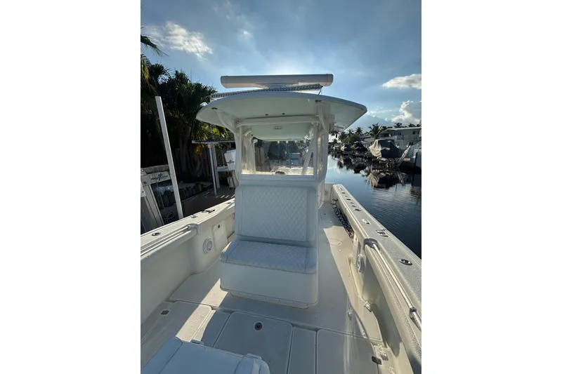 Slide: The Image of 2012 Yellowfin 32 Offshore boat interior with seating, docked by a calm waterfront. - 9