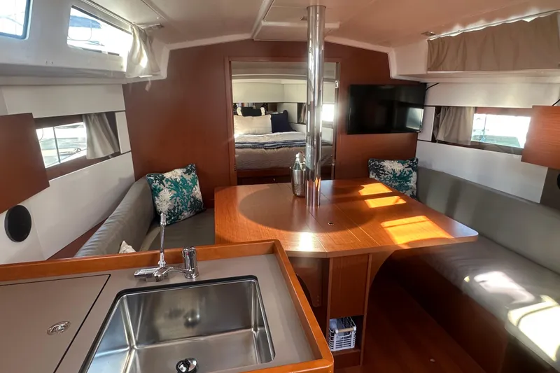 Slide: The Image of Interior of 2019 Beneteau Oceanis 38.1 yacht with modern kitchen and cozy seating area. - 10