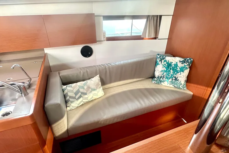 Slide: The Image of Interior of 2019 Beneteau Oceanis 38.1 yacht with cozy seating and decorative pillows. - 13