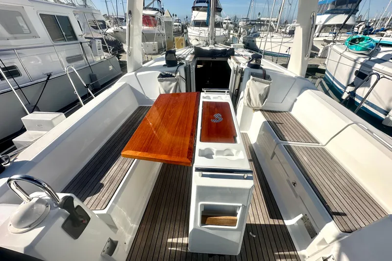 Slide: The Image of 2019 Beneteau Oceanis 38.1 yacht cockpit with wooden table and seating, docked at marina. - 14