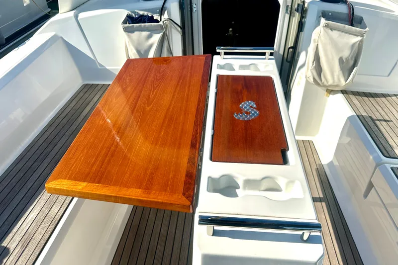 Slide: The Image of Cockpit of 2019 Beneteau Oceanis 38.1 with wooden table and storage compartments. - 15
