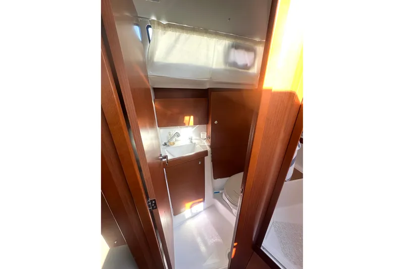 Slide: The Image of Interior view of 2019 Beneteau Oceanis 38.1 bathroom with wooden cabinetry and compact design. - 8