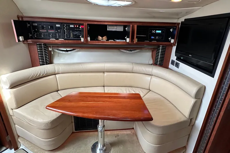 Slide: The Image of 2009 Monterey 350 Sport Yacht interior with beige seating, wooden table, and control panels. - 18
