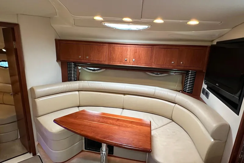 Slide: The Image of 2009 Monterey 350 Sport Yacht interior with leather seating, wooden table, and wall-mounted TV. - 19
